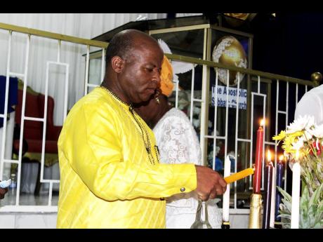 Photo by A worshipper lights a candle at a Revival table.