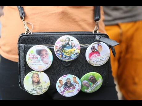 A resident wears buttons memorialising six of the eight people killed.