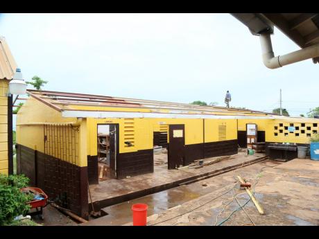 
A workman carrying out repairs on the roofless grade six block at Top Hill Primary School in St Elizabeth last Friday.