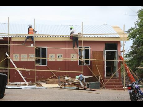 Workmen effecting repairs to the computer lab and library at Pedro Plains Primary School in St Elizabeth last Friday.