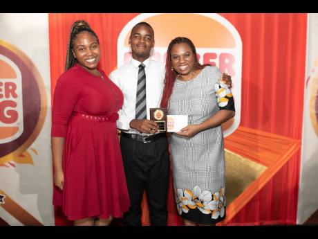 Brandon Farquharson (centre), Burger King Open Male scholarship recipient, with Rashai Graham (left), assistant brand manager, Burger King Jamaica, and Nadia Kiffin Green, head of sales & marketing at Restaurant Associates Limited, after the announcement o