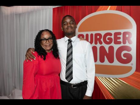 Maureen Morris (left) embraces her son, Brandon Farquharson, Burger King Open Male scholarship recipient, during last Thursday’s Burger King Scholarship Awards Luncheon.