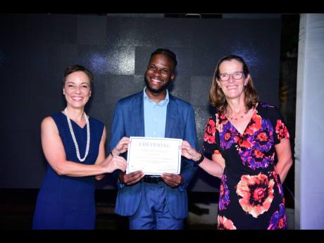 Najae Murray (centre) collects his Chevening scholarship certificate from Senator Kamina Johnson Smith (left), minister of foreign affairs and foreign trade, and Judith Slater, British high commissioner to Jamaica, at the Windrush Gardens, British High Com