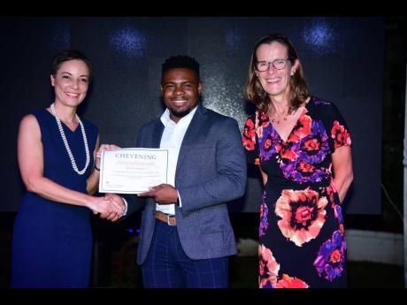 Senator Kamina Johnson Smith (left), minister of foreign affairs and foreign trade, and Judith Slater, British high commissioner to Jamaica, present Anthony McKenzie with his certificate of acceptance at the 2024 Chevening Scholarship Award Ceremony and Re