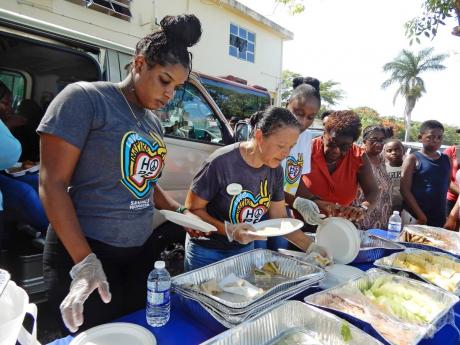 Lyndsay Isaacs (second left), regional public relations manager, Sandals, and other team members, serve refreshments for the crowd during the St Ann police health fair and treat last Thursday.