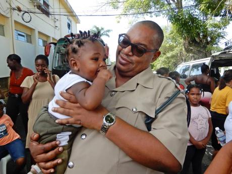 Seven month-old Dontae Brissett, affectionately called Chubby, of St Ann’s Bay, was happy to be in the company of Deputy Superintendent of Police Kevon Chambers, of the St Ann police division, at the health fair and treat.