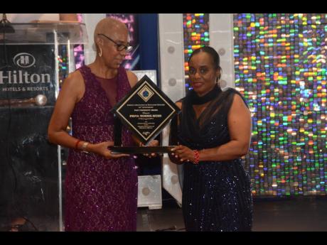 Minister of Education and Youth Fayval Williams (left) presents an award for outstanding leadership to Fiona Morris-Webb, immediate past president of the Jamaica Association of Education Officers, during the organisation’s 60th Anniversary Banquet and In