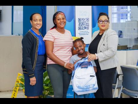 Members of the NCB team from the Santa Cruz branch, Barbara Cohen (right), branch manager, and Sachana Powell-Reynolds (left), business banker, share a proud moment with Samoya Bennett and her niece, Annakay Smith, as they receive a brand-new backpack fill