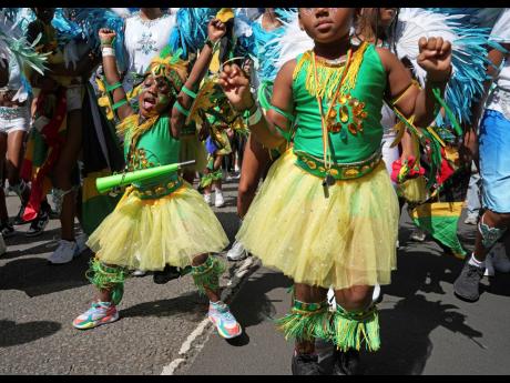 Participants take part in the Children’s Day Parade, part of the Notting Hill Carnival celebration in west London, Sunday. 