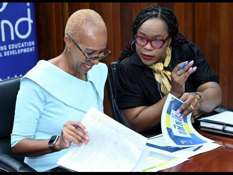 Education Minister Fayval Williams (left) and Dr Kasan Troupe, permanent secretary in the Ministry of Education, peruse the report on Jamaica’s May-June 2024 CSEC/CAPE results before presenting the information at a press conference on Monday.