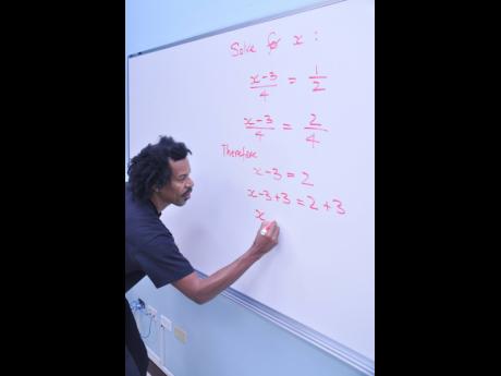 Dr Samuel McDaniel demonstrates how to tackle a CSEC mathemaics problem during a 2013 Gleaner interview.