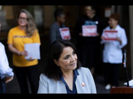 Kim Cordova, president of UFCW 7, centre, speaks to reporters after a news conference about the Kroger and Albertsons merger outside the federal courthouse before a hearing on the merger on August 26, 2024, in Portland, Oregon.