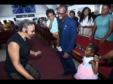 Reverend Dr Michelle Harris-Thompson (left) greeting Paul Brissett, president of the Rotary Club of Downtown Kingston, and his children Marissa (right) and Melech during a service at the Webster Memorial United Church in St Andrew on August 18.