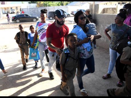 Students with their parents at Alpha Primary School for the first day back to school at Alpha Primary on Camp Road in Kingston last year. 