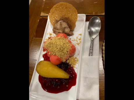 Ginger chocolate mousse, citrus Scotch bonnet crumble, and mixed-berry panna cotta topped with drunken pear wedges.