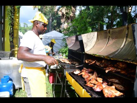 Garnett White of Garnett’s Gourmet Catering ensures that the jerk chicken is hot, ready and tasty for patrons attending the festival.