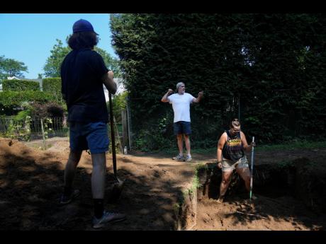 Joseph Diamond, associate professor of anthropology at New Paltz, talks to some of his students as they work at the site of an African burial ground in Kingston, New York.