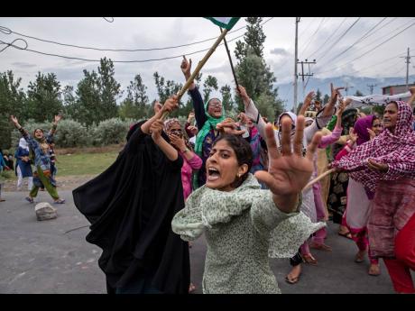 Women shout slogans as Indian policemen fire teargas and live ammunition in the air to stop a protest march in Srinagar.