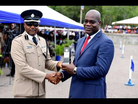 Deputy Commissioner of Police Fitz Bailey (right) was recognised for his years of service ahead of his retirement at the Jamaica Constabulary Force’s passing-out parade held on August 28 at the National Police College of Jamaica.