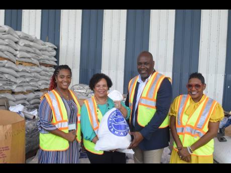 Shipping Association of Jamaica President Corah Ann Robertson-Sylvester (second left) and Deputy General Manager Terrence Brooks display one of the numerous packages distributed by Food For The Poor in its service to over 300,000 people monthly, as its exe