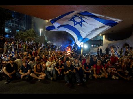 People block a road as they protest, calling for a deal for the immediate release of hostages held in the Gaza Strip by Hamas, in Tel Aviv, Israel on Sunday.