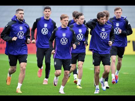 Germany’s players, from left: Robert Andrich, Aleksandar Pavlovic, Joshua Kimmich, Pascal Groß, Rocco Reitz, Thomas Müller, Maximilian Mittelstädt and Maximilian Beier warm up in a training session in Herzogenaurach, Germany on June 1.