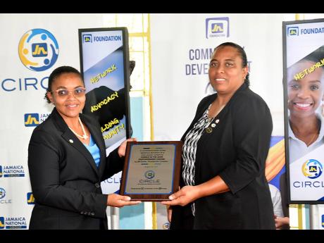 Claudine Allen (left), general manager of the JN Foundation, and Dr Wendy Freckleton, president of the JN Circle Mandeville chapter and chairman of Candle in the Dark Ministries, showcase the plaque to commemorate the donation of a solar energy system to t