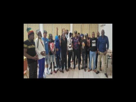 Prime Minister Gaston Browne (centre with cap) with members of the Grays Farm Killers gang following Monday night’s meeting.