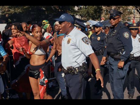 Police move revellers from the street after a shooting on Eastern Parkway, near the corner of Franklin Avenue, during the West Indian Day Parade on Monday.