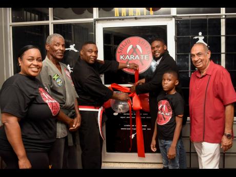 Mayor of Montego Bay Richard Vernon (third right) cuts the ribbon to declare open the Shijo Saiko Martial Arts Academy along with its owner, Terrence Thomas (third left) at Blue Diamond Shopping Centre on Saturday. Also pictured are from left: Collette Bar