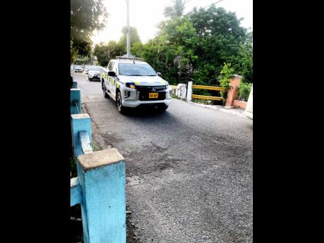 Police service vehicle patrols the spot on Dames Road in Allman Town, Kingston, where Keauno Watson and another man were shot. 