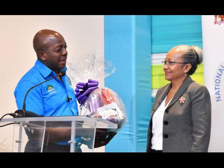 Pearnel Charles Jr (left), minister of labour and social security, thanks Collette Roberts Risden, his outgoing permanent secretary, for the job she did in serving that ministry. She has been reassigned to Washington, DC, to focus more on the farm work pro