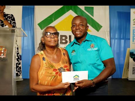 Pearnel Charles Jr, Minister of Labour and Social Security, with Arleen Waul, a beneficiary of the Rebuild Jamaica initiative, during the Rebuild Jamaica cheque handover at the Morant Villas Hotel in St Thomas on Tuesday, September 3.