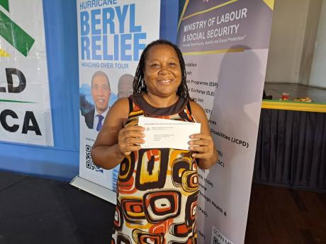 Angella Allen, of Claremont, Hanover, showcases her financial grant which she received during a hand over of grants to beneficiaries of the Ministry of Labour and Social Security's Rebuild Jamaica Programme, at the Montego Bay Cultural Centre in St James o