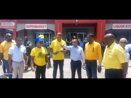 Michael Lee-Chin (fifth right), chairman of NCB Financial Group, listens to development plans from Moses Chybar (fourth right), managing director at ICON Importers and Distributors, in Savanna-la-Mar, Westmoreland, as other members of a touring party look 