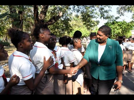 Sian Wilson (right), then acting principal of Calabar High School, shakes hands with students of Mona High School when she led a delegation from Calabar to the school in May to improve the relationship between the schools.