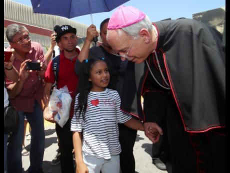 
El Paso Catholic Bishop Mark Seitz talks with Celsia Palma, nine, of Honduras, as they walked to the Paso Del Norte International Port of Entry on June, 27, 2019, in Juarez, Mexico. 