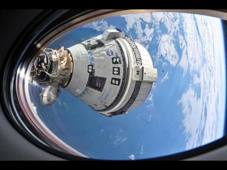 This photo provided by NASA shows Boeing’s Starliner spacecraft which launched astronauts Butch Wilmore and Suni Williams to the International Space Station docked to the Harmony module’s forward port on July 3, seen from a window on the SpaceX Dragon 