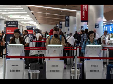 Travellers use kiosks to check in for flights in the Delta Airlines ticketing area at the Los Angeles International Airport in Los Angeles, Friday, August 30, 2024.