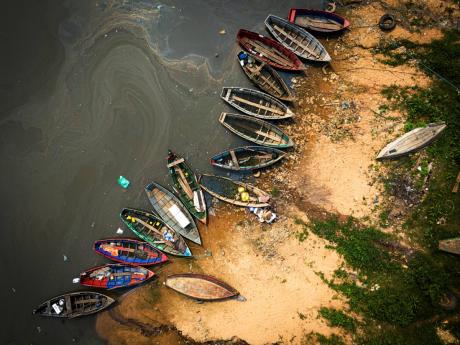 Fishing boats sit on the shore of the Paraguay River in Mariano Roque Alonso, Paraguay, Monday, September 9, 2024. Water levels have plunged to their lowest-ever level amid a drought, according to Paraguay’s Meteorology and Hydrology Office.