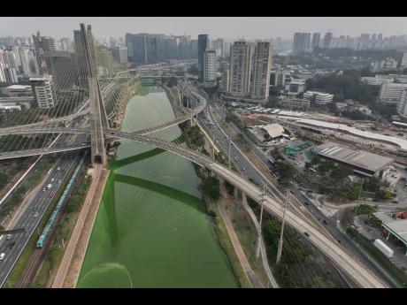 The Pinheiros River is green in Sao Paulo, Brazil, Tuesday, September 10, 2024. The state’s environmental authority attributes the river’s new green hue to an algae bloom, the result of severe drought that has significantly lowered water levels.