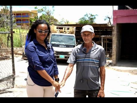 Collen Dyer, project administrator, M&M Jamaica Limited, meets with a St Elizabeth resident, as he described how Hurricane Beryl tore his roof off completely.  He was also expressing his gratitude to M&M Jamaica for the company’s kind donation of buildin