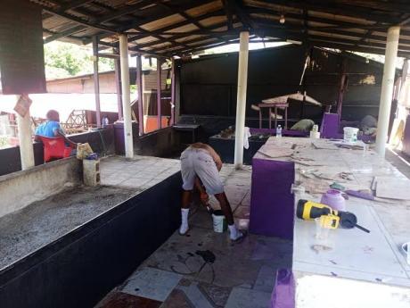 Jerk vendors carry out rehabilitation and painting work at the Boston Jerk Centre in Portland.