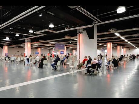 People rest after receiving the vaccination against the new coronavirus in the ‘Austria Center Vienna’ in Vienna, Austria, Friday, April 9, 2021. 