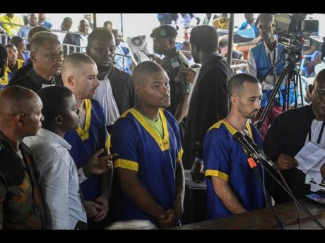 From left: Tyler Thompson Jr, Marcel Malanga and Benjamin Reuben Zalman-Polun, all American citizens, face the court in Kinshasa with 52 other defendants on June 7, accused of a role in last month’s attempted coup in Congo led by little-known opposition 