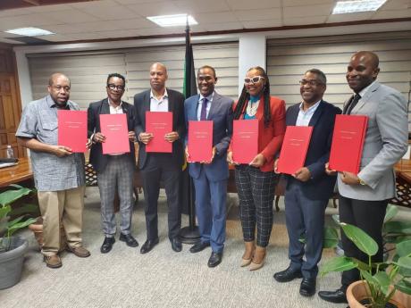 Finance Minister Dr Nigel Clarke (centre) and member unions of the Jamaica Confederation of Trade Unions inked the long negotiated public sector compensation restructuring agreement on Thursday.