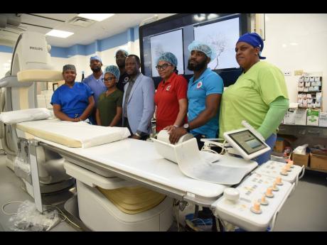 Dr Kevin Wade (centre), consultant neurosurgeon at the University Hospitalof the West Indies, flanked by members of his team at the Tony Thwaites Wing at the St Andrew-based medical facility.