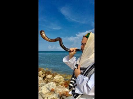 Rabbi Raskin sounds the shofar overlooking the Caribbean Sea.  