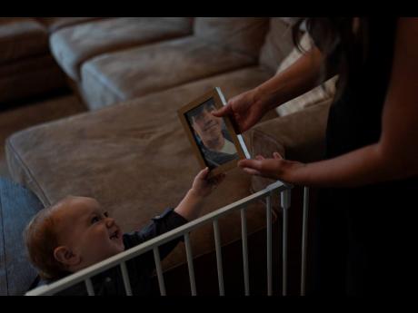 Mikayla Brown (right) shows a photo of Elijah Ott, who died of a fentanyl overdose at 15, to her youngest son, Crew, at their home in Atascadero, California.