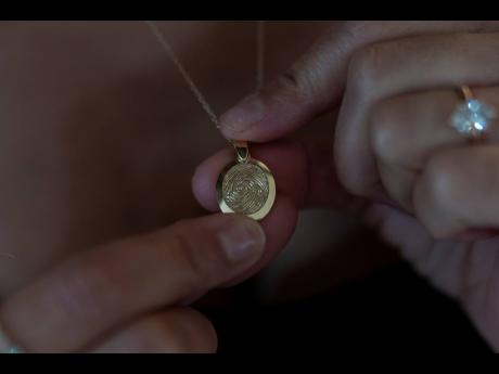 Mikayla Brown shows a pendant etched with the fingerprint of her son, Elijah Ott.